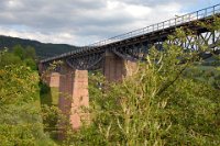 Talübergang Fützen - Widerlager in Richtung Grimmelshofen (07/2010)  Mit dem Talübergang Fützen wechselt die Trasse von der linken auf die rechte Talseite des Mühlbachtals. Die Frage, ob die Überquerung mittels eines Dammes oder einer Brücke erfolgen sollte, wurde durch die günstigeren Kosten für die Brücke entschieden. Das Viadukt mit vier Öffnungen zu je 37,5 Metern Spannweite wurde zwischen 1888 und 1890 erbaut. Die Gesamtlänge der Brücke beträgt 153 Meter bei einer Höhe von 28 Metern. Im Gegensatz zum Biesenbach-Viadukt ruhen hier die Fischbauchträger auf steinernen Pfeilern aus Kalkstein, die wie die Widerlager mit Sandstein verblendet wurden.    viadukt fuetzen widerlager grimmelshofen 3 bogen-DSC 0190  Talübergang Fützen - Widerlager in Richtung Grimmelshofen (07/2010)  Mit dem Talübergang Fützen wechselt die Trasse von der linken auf die rechte Talseite des Mühlbachtals. Die Frage, ob die Überquerung mittels eines Dammes oder einer Brücke erfolgen sollte, wurde durch die günstigeren Kosten für die Brücke entschieden. Das Viadukt mit vier Öffnungen zu je 37,5 Metern Spannweite wurde zwischen 1888 und 1890 erbaut. Die Gesamtlänge der Brücke beträgt 153 Meter bei einer Höhe von 28 Metern. Im Gegensatz zum Biesenbach-Viadukt ruhen hier die Fischbauchträger auf steinernen Pfeilern aus Kalkstein, die wie die Widerlager mit Sandstein verblendet wurden.  --> : Wutachtalbahn, Sauschwänzelbahn, Sauschwänzlesbahn, Blumberg-Zollhaus, Weizen, Manfred, Detzner, Speyer, Fützen, Talübergang, Viadukt