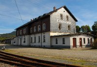 Bf Cranzahl: Straßenseite - 654 m ü. NN (09/10 2014) Durch die Umschlagstelle bzw. die Rollbockgrube von Regelspur- zu Schmalspurbahn, die sich an der Straße vor dem Gebäude befindet, liegt das Gebäude in Insellage. Bahnsteig 2 ist ausschließlich der Regelspur vorbehalten, an Bahnsteig 1 halten in Fahrtrichtung Oberwiesenthal an der linken Banhnsteigklante die Schmalspurzüge, an der rechten die Regelspurzüge. Cranzahl erhielt an der am 3. August 1872 eröffneten Bahnstrecke Weipert–Annaberg einen Bahnanschluss. 1880 wurde der erste Teil des heutigen Empfangsgebäudes errichtet. Mit dem Bau der Schmalspurbahn im Jahr 1894 wurde auch der Bahnhof erweitert. Das Empfangsgebäude wurde ebenfalls umgebaut und erhielt seine heutige Form.    DSC 0053  Bf Cranzahl: Straßenseite - 654 m ü. NN (09/10 2014) Durch die Umschlagstelle bzw. die Rollbockgrube von Regelspur- zu Schmalspurbahn, die sich an der Straße vor dem Gebäude befindet, liegt das Gebäude in Insellage. Bahnsteig 2 ist ausschließlich der Regelspur vorbehalten, an Bahnsteig 1 halten in Fahrtrichtung Oberwiesenthal an der linken Banhnsteigklante die Schmalspurzüge, an der rechten die Regelspurzüge. Cranzahl erhielt an der am 3. August 1872 eröffneten Bahnstrecke Weipert–Annaberg einen Bahnanschluss. 1880 wurde der erste Teil des heutigen Empfangsgebäudes errichtet. Mit dem Bau der Schmalspurbahn im Jahr 1894 wurde auch der Bahnhof erweitert. Das Empfangsgebäude wurde ebenfalls umgebaut und erhielt seine heutige Form.  --> : Fichtelbergbahn, Cranzahl, Oberwiesenthal, Manfred Detzner, Speyer, Bf, Bahnhof, Empfangsgebäude, Straßenseite