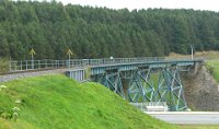 Kurort Oberwiesenthal - Viadukt Hüttenbachtal - 888 m ü. NN (09/10 2014) Das Gerüstpfeilerviadukt liegt in einer Steigung von 3,3 % und einem Gleisbogen mit 350 m Radius. Die einzelnen Brückenteile wurden in Lauchhammer angefertigt und vor Ort zusammengebaut. Die vier Brückenfelder haben bei einer Gesamtlänge von 100 m eine lichte Weite von 17,5 m. Die Höhe des Viadukts beträgt 18 m. In den 1920er Jahren wurden die Brückenfelder durch einen Unterzug für eine höhere Achslast ergänzt.    DSC 0336  Kurort Oberwiesenthal - Viadukt Hüttenbachtal - 888 m ü. NN (09/10 2014) Das Gerüstpfeilerviadukt liegt in einer Steigung von 3,3 % und einem Gleisbogen mit 350 m Radius. Die einzelnen Brückenteile wurden in Lauchhammer angefertigt und vor Ort zusammengebaut. Die vier Brückenfelder haben bei einer Gesamtlänge von 100 m eine lichte Weite von 17,5 m. Die Höhe des Viadukts beträgt 18 m. In den 1920er Jahren wurden die Brückenfelder durch einen Unterzug für eine höhere Achslast ergänzt.  --> : Fichtelbergbahn, Cranzahl, Oberwiesenthal, Manfred Detzner, Speyer, Bf, Bahnhof, Kurort Oberwiesenthal, Viadukt, Hüttenbachtal