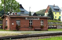 Bf Hammerunterwiesenthal: Gleisseite - 796 m ü. NN (09/10 2014) Der Bahnhof bestand 1897 nur aus durchgehenden Hauptgleis und einem beidseitig eingebundenen Ladegleis, von dem nach jeder Seite ein kurzes Stumpfgleis abzweigte. Auch die vorhandene massive Wartehalle entstand zu dieser Zeit. Bereits nach vier Jahren wurde die Station erweitert: Neben dem benachbarten Kalk- und Schotterwerk wurden ein Sägewerk und einer benachbarten Fabrik im Böhmischen bedient. Eine zweite Erweiterung wurde 1912 nötig, als Abstellmöglichkeiten für Wintersportsonderzüge geschaffen wurden. Eine letzte Ergänzung war 1928, als das Kalk- und Schotterwerk die Produktion ausweitete. Der Großteil des Güterverkehrs wurde bis 1992 über diesen Bahnhof abgewickelt. Zuletzt war das Schotterwerk als Hauptkunde verblieben. 2001 wurde eine Betriebsmittelüberladerampe gebaut, wo Schmalspurfahrzeuge auf Tieflader verladen werden können.    DSC 0361  Bf Hammerunterwiesenthal: Gleisseite - 796 m ü. NN (09/10 2014) Der Bahnhof bestand 1897 nur aus durchgehenden Hauptgleis und einem beidseitig eingebundenen Ladegleis, von dem nach jeder Seite ein kurzes Stumpfgleis abzweigte. Auch die vorhandene massive Wartehalle entstand zu dieser Zeit. Bereits nach vier Jahren wurde die Station erweitert: Neben dem benachbarten Kalk- und Schotterwerk wurden ein Sägewerk und einer benachbarten Fabrik im Böhmischen bedient. Eine zweite Erweiterung wurde 1912 nötig, als Abstellmöglichkeiten für Wintersportsonderzüge geschaffen wurden. Eine letzte Ergänzung war 1928, als das Kalk- und Schotterwerk die Produktion ausweitete. Der Großteil des Güterverkehrs wurde bis 1992 über diesen Bahnhof abgewickelt. Zuletzt war das Schotterwerk als Hauptkunde verblieben. 2001 wurde eine Betriebsmittelüberladerampe gebaut, wo Schmalspurfahrzeuge auf Tieflader verladen werden können.  --> : Fichtelbergbahn, Cranzahl, Oberwiesenthal, Manfred Detzner, Speyer, Bf, Bahnhof, Hammerunterwiesenthal, Gleisseite